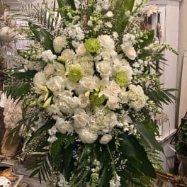 Large white floral standing arrangement with roses and lilies