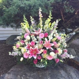 Large pink and white floral arrangement in a white basket