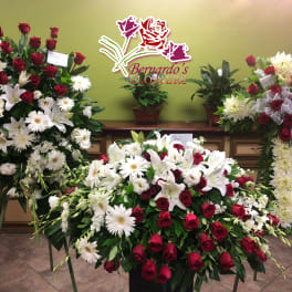 Large funeral floral sprays with red roses and white lilies and daisies