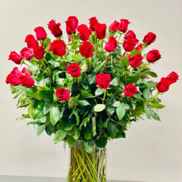 Tall bouquet of red roses in a clear glass vase