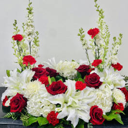 Red roses and white lilies arranged with white hydrangeas and carnations