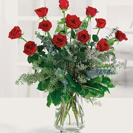 Red roses arranged in a clear glass vase