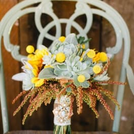Bouquet of succulents and yellow flowers with a decorative handle wrap