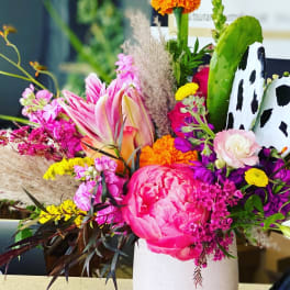 Colorful mixed bouquet in a white vase with pink and orange blooms