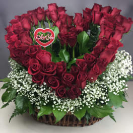 Heart-shaped red rose arrangement in a wicker basket with baby's breath