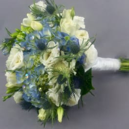 Blue and white bridal bouquet with spiky thistles and wrapped stems