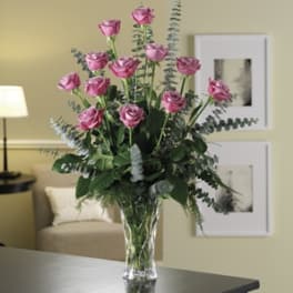 Pink roses in a clear glass vase with eucalyptus