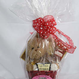 Gift basket with a teddy bear, chocolates, and a red heart ribbon