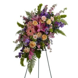 Standing floral spray with pink, purple, and peach blooms on an easel