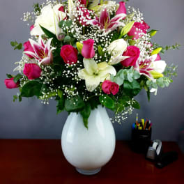 Pink roses and white lilies in a white vase