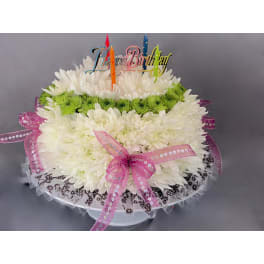 White chrysanthemum cake with candles and a birthday topper