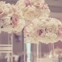 Blush and white rose arrangements in tall clear vases