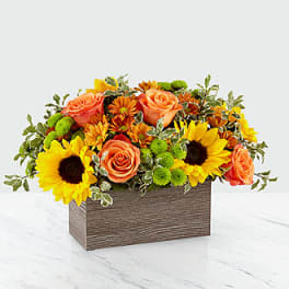 Sunflowers and orange roses in a rectangular wooden box