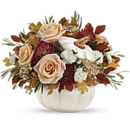 Autumn floral arrangement with peach roses in a white pumpkin vase