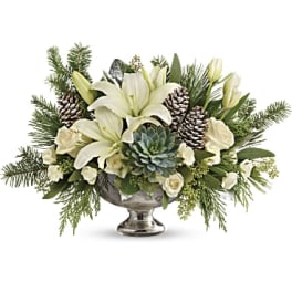 White lilies and roses arranged in a silver pedestal bowl
