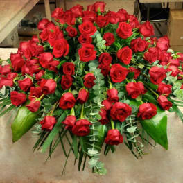 Large bouquet of red roses with greenery on a table