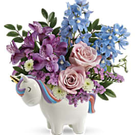 Pink and blue flowers arranged in a unicorn-shaped vase