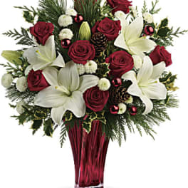 Red roses and white lilies arranged in a red glass vase