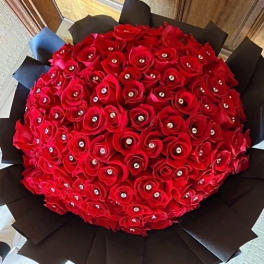 Large round bouquet of red roses wrapped in black paper