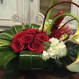 Red roses with white calla lilies and hydrangea in a low arrangement