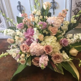 Large pastel floral arrangement with roses, hydrangeas, and lilies