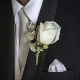 White rose boutonniere on a black suit jacket