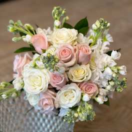 Bouquet of pale pink and white roses with white blossoms in a glass vase