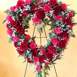 Heart-shaped rose wreath on a stand with red and pink roses