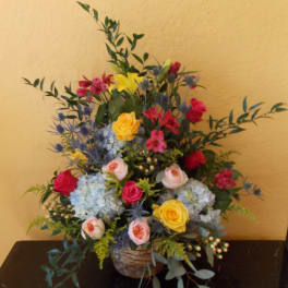 Colorful mixed flower arrangement in a woven basket