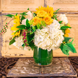 Yellow sunflowers and white hydrangeas in a glass vase