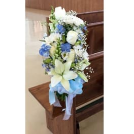 Tall blue and white floral arrangement with ribbon on a wooden stand