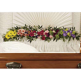 Colorful floral spray arranged across a casket