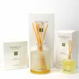 Three boxed reed diffusers with a clear amber bottle in the center
