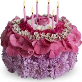 Pink and purple floral cake with five lit candles