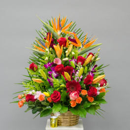 Large tropical bouquet with roses, lilies, and bird of paradise in a basket