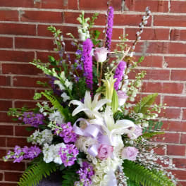 Tall floral arrangement with white lilies and lavender roses