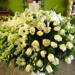 Large white floral arrangement with roses, lilies, and daisies
