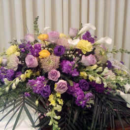 Large floral arrangement with purple, pink, yellow, and white blooms