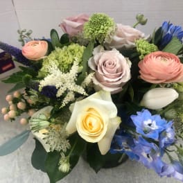 Mixed bouquet with roses, ranunculus, and blue flowers