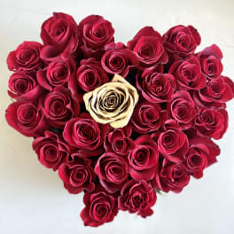 Heart-shaped bouquet of red roses with one cream rose in the center
