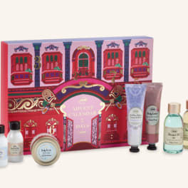 Advent calendar gift box with assorted bath and body products in bottles, tubes, and a tin