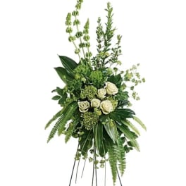 White roses and greenery in a tall standing spray