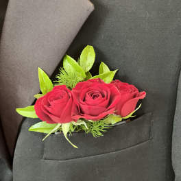 Red rose boutonniere pinned to a black suit jacket