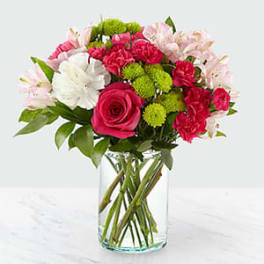 Bouquet of pink, white, and green flowers in a clear glass vase