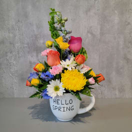 Colorful spring bouquet in a white mug with "HELLO SPRING" text