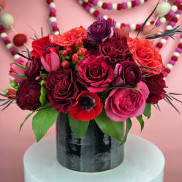 Bouquet of red, pink, and purple flowers in a black vase
