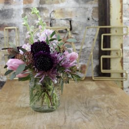 Pink and purple bouquet in a clear glass jar vase