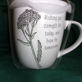 White mug with a floral line drawing and printed message in a clear gift wrap