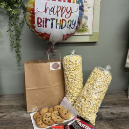 Birthday balloon with snack gift bag, popcorn, cookies, and candy