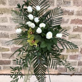 Tall floral standing spray with white roses and tropical greenery